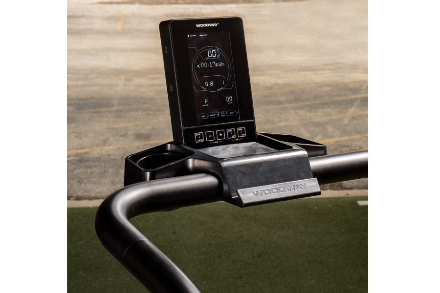 Woodway Curve LTG treadmill with digital console mounted on curved black handlebar, displayed on green mat