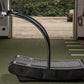 Black curved treadmill with arched running deck and dual handles, positioned in RV interior with open door view