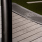 Woodway Curve LTG treadmill running surface with textured belt and black handrail, on artificial turf background