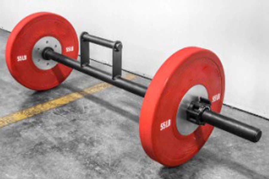 Red weight plate barbell with black steel bar and farmer's carry handles on concrete floor