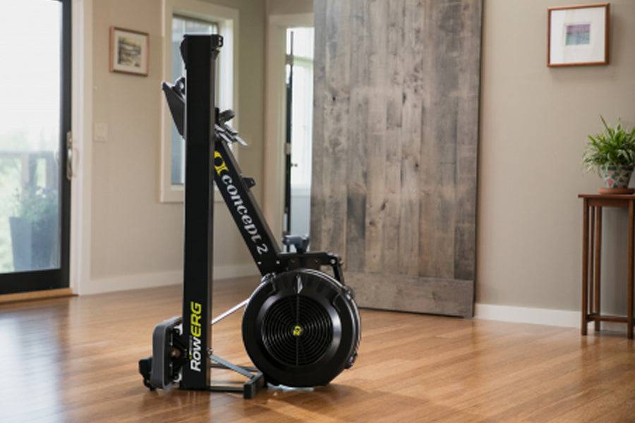 Concept2 RowErg black indoor rowing machine with tall vertical rail and circular resistance fan, displayed in home setting on