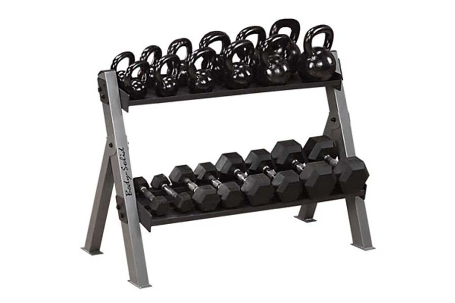 Two-tier gray metal dumbbell and kettlebell rack holding black hexagonal dumbbells on lower shelf and black kettlebells with 
