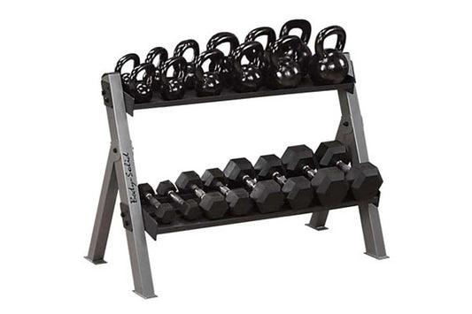 Two-tier gray metal dumbbell and kettlebell rack holding black hexagonal dumbbells on lower shelf and black kettlebells with 