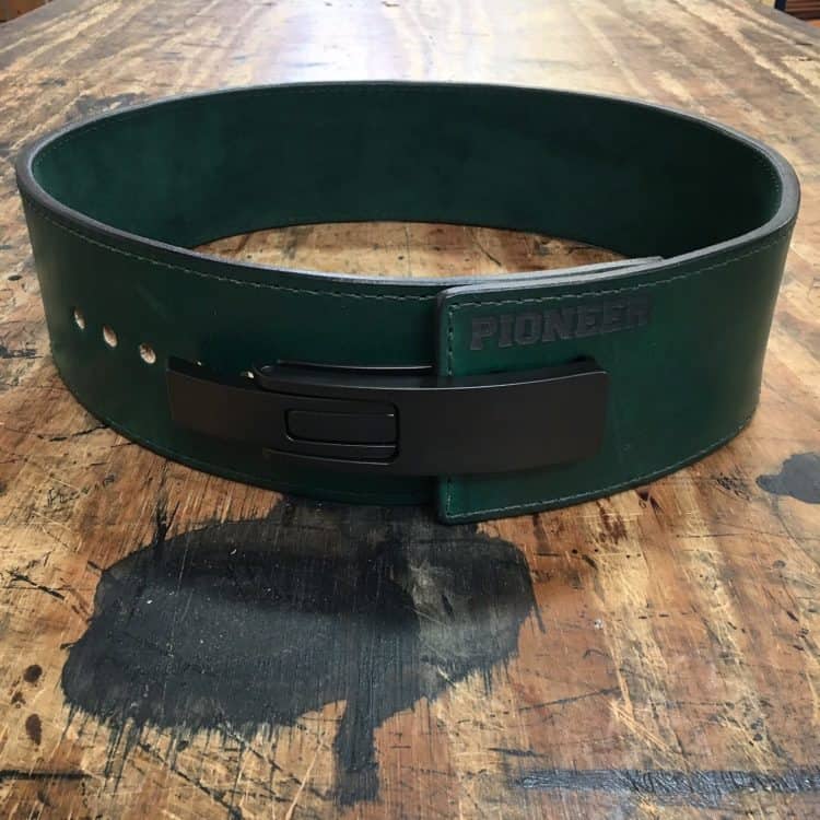 Green leather weightlifting belt with black lever buckle and Pioneer branding on wood surface