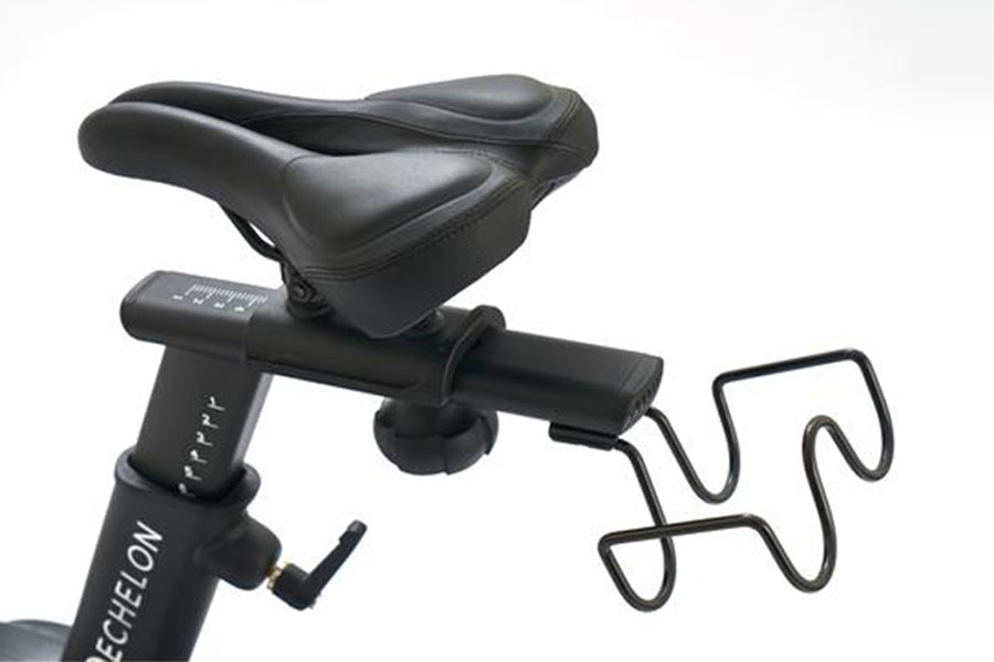 Black leather exercise bike seat mounted on Echelon Connect Bike EX-7s with adjustable handlebar and pedal strap visible
