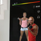 Echelon Reflect 40 smart fitness mirror displaying workout interface with two people exercising with dumbbells on black scree