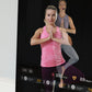 Echelon Reflect Touch 50 smart fitness mirror displaying woman in pink tank top and gray leggings performing yoga pose with i