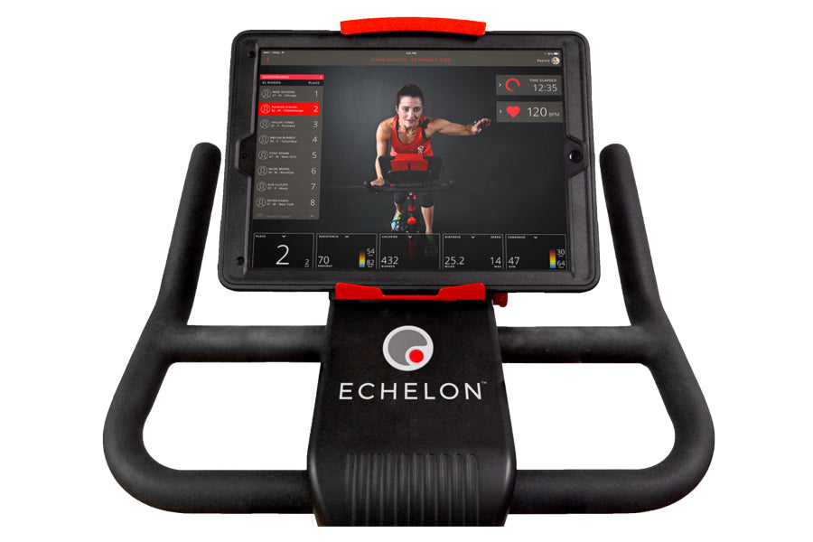 Black Echelon Connect Bike EX-3 with red accents, tablet mounted on handlebar displaying fitness class interface on white bac