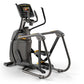 Black and gray elliptical fitness machine with digital display console and yellow accent details, viewed from the side on whi