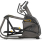 Black and gray elliptical trainer with yellow accents, dual handles, and foot pedals on white background