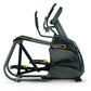 Black elliptical trainer with yellow accents, dual handles, pedals, and digital display on white background