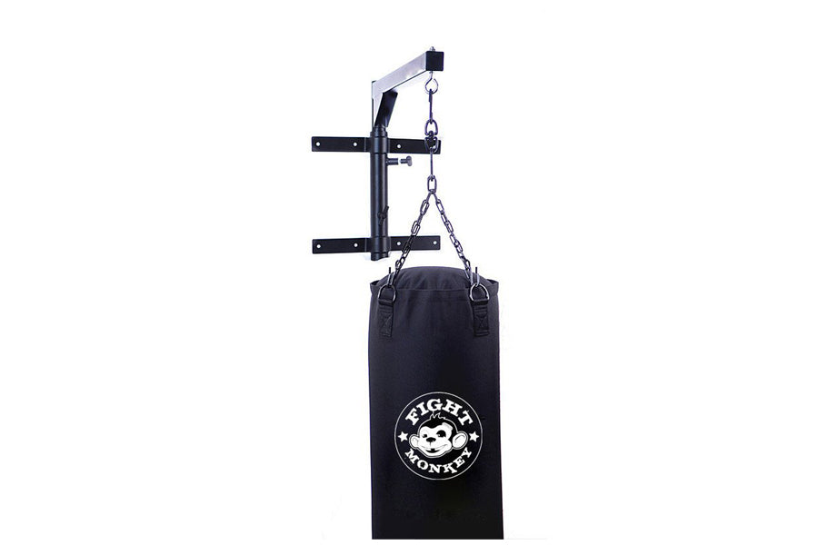 Black heavy bag with white Fight Monkey logo hanging from metal wall-mounted pull-up bar with chain, on white background