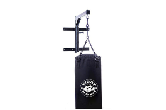 Black heavy bag with white Fight Monkey logo hanging from metal wall-mounted pull-up bar with chain, on white background