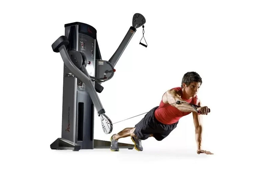 Black and gray dual cable cross exercise machine with model demonstrating suspended plank position using resistance cables