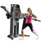 Woman using black dual cable crossover machine with pink top and black capris, demonstrating chest fly exercise on white back