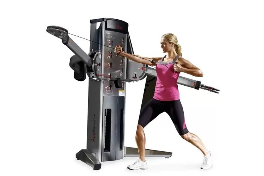 Woman using black dual cable crossover machine with pink top and black capris, demonstrating chest fly exercise on white back