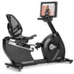 Freemotion r22.9 recumbent exercise bike with black frame, mesh backrest, and integrated touchscreen display showing workout 