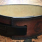 Brown leather weightlifting belt with cream suede lining and black metal buckle closure, displayed on wooden surface