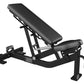 Hammer Strength black adjustable weight bench with incline backrest and leg extension attachment on white background