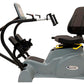 Gray and black recumbent elliptical exercise machine with digital display, pedals, and padded seat on white background