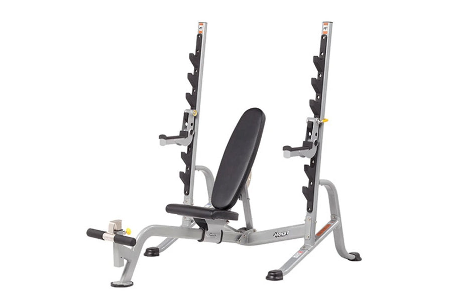Multi-purpose squat rack with silver frame, black padded seat, dual weight bar holders, and adjustable safety arms on white b