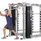 Man in blue tank top using Hoist Mi7Smith functional training system with cable machine, silver and black metal frame on whit