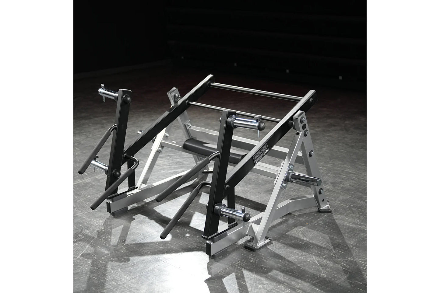 Hammer Strength Ground Base Multi-Squat Machine with black uprights and silver steel frame on dark textured floor
