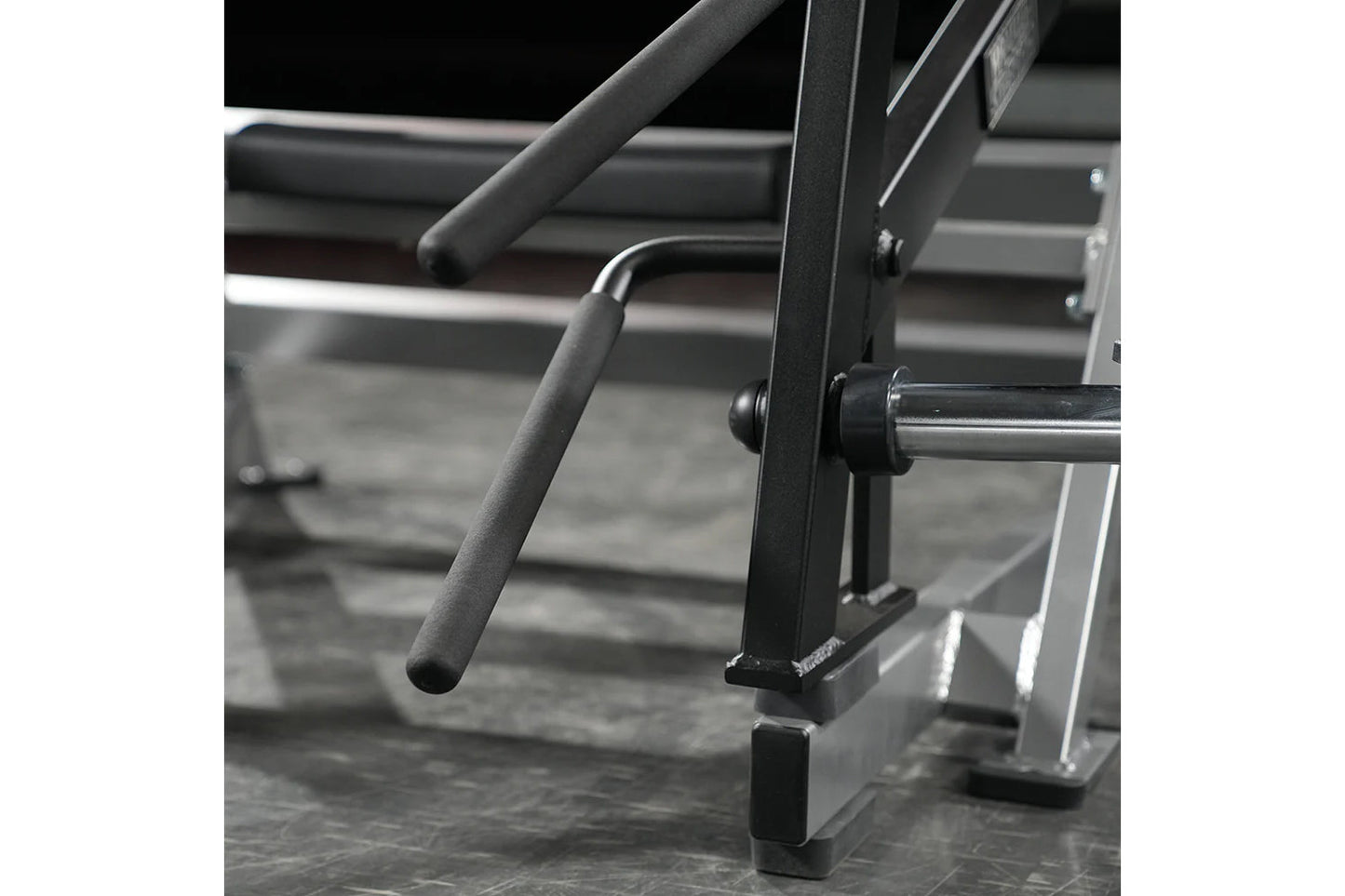 Hammer Strength Ground Base Multi-Squat Machine with black foam handles and chrome bars on gray gymnasium floor