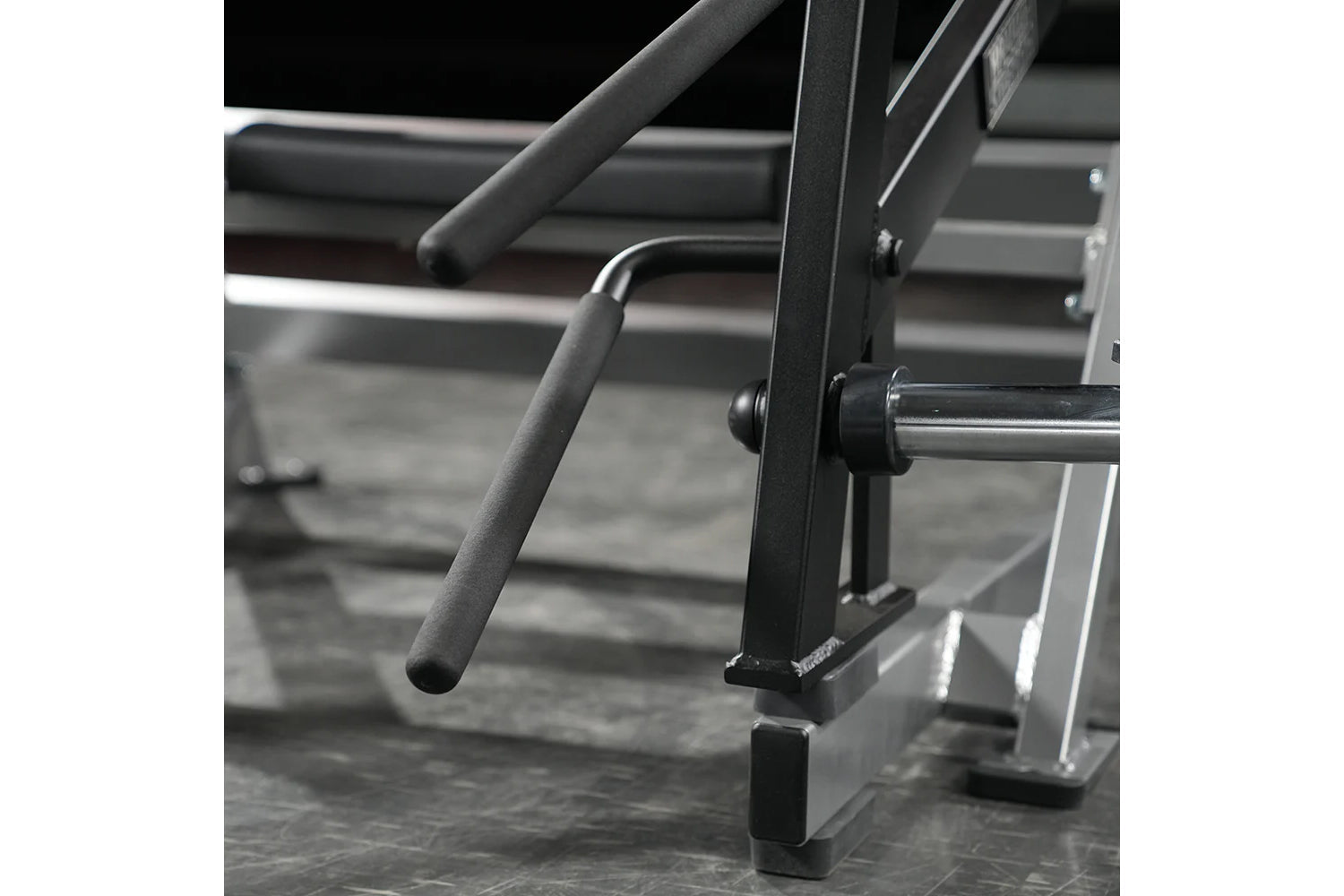 Hammer Strength Ground Base Multi-Squat Machine with black foam handles and chrome bars on gray gymnasium floor