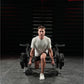 Man wearing sage green t-shirt and black shorts performing squat exercise on Hammer Strength Ground Base Multi-Squat Machine 
