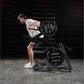 Man in gray tank top and black shorts performing squat exercise on Hammer Strength black multi-squat machine with loaded weig