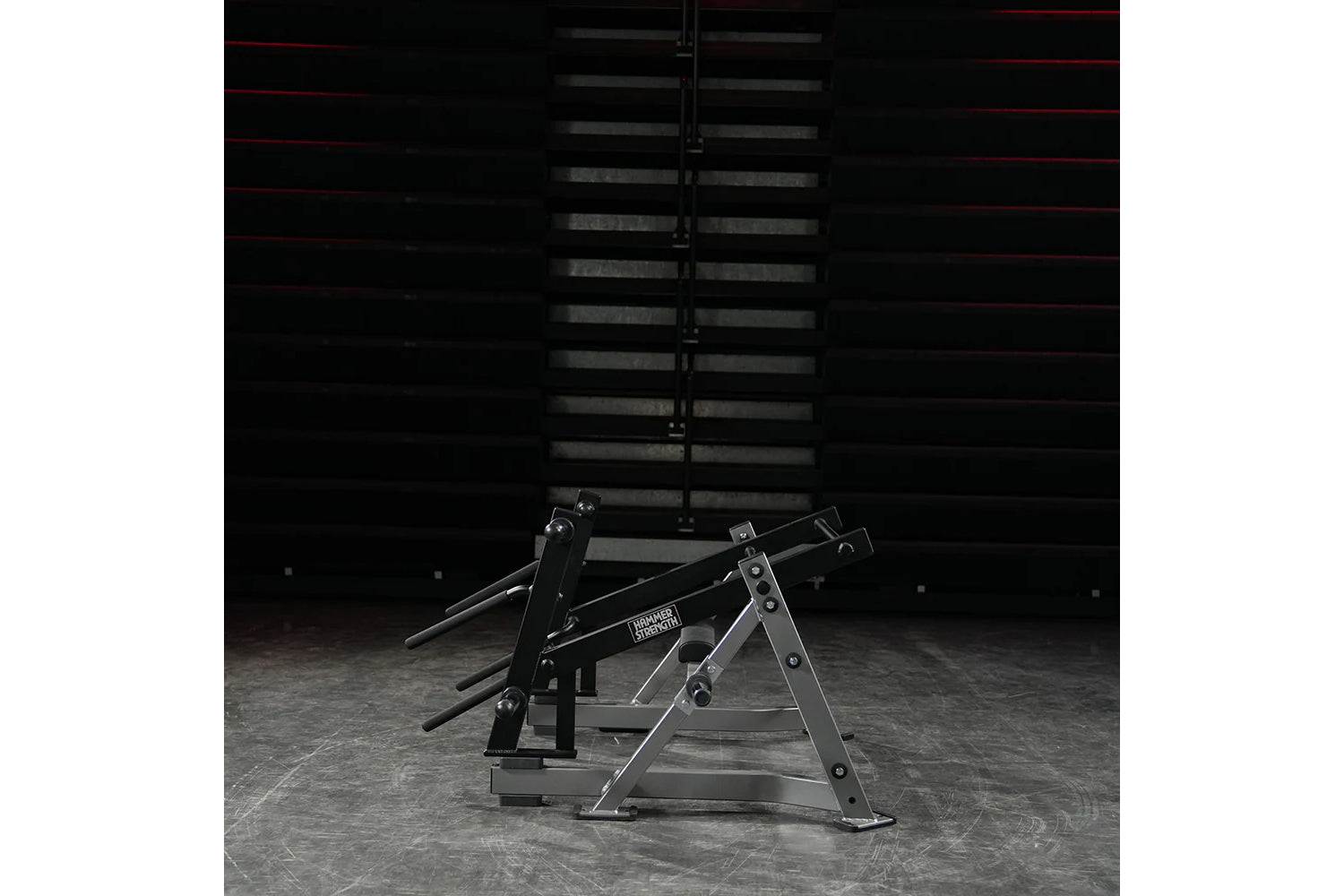 Hammer Strength Ground Base Multi-Squat Machine with black and gray metal frame on concrete floor in gym setting