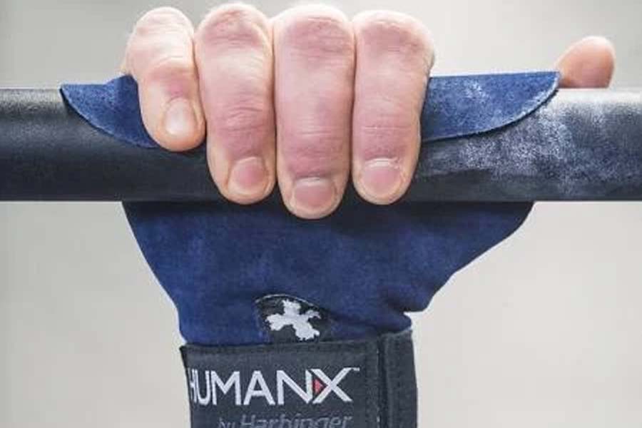 Navy blue wrist-wrap pull-up grips with black padding worn by hand gripping bar, showing grip detail