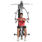 Man in red shirt using gray and black chest press machine on white background