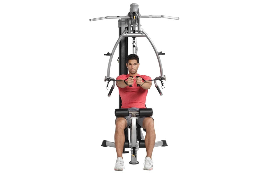 Man in red shirt using gray and black chest press machine on white background
