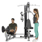 Black and silver Hoist Mi1 multi-station home gym with two models demonstrating leg press and chest press exercises