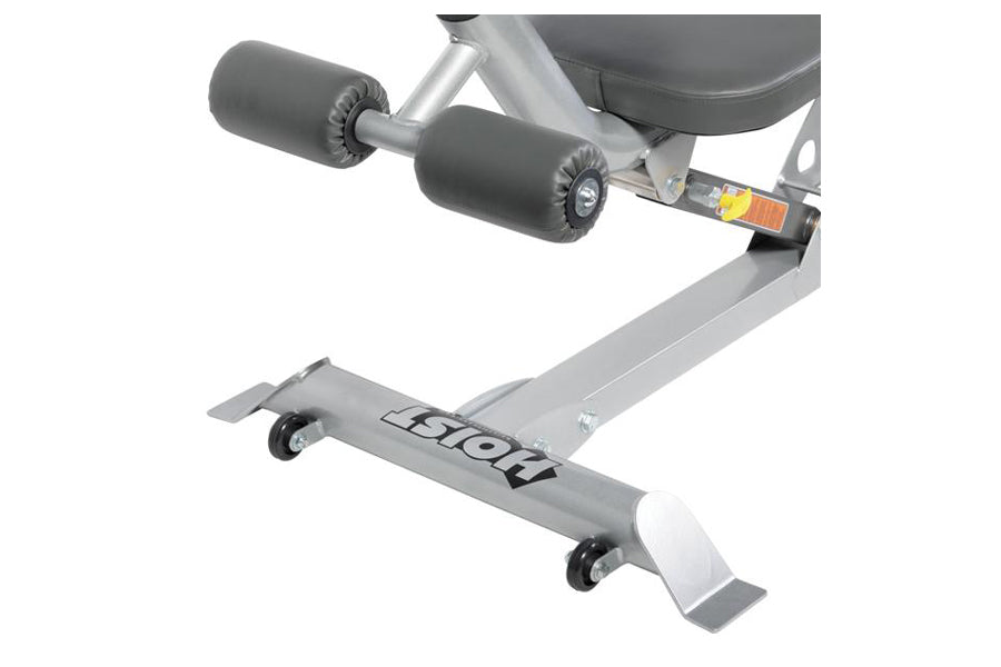 Gray stationary ab bench with black padded footrest rollers, white foot platform, and casters, shown from angled view on whit
