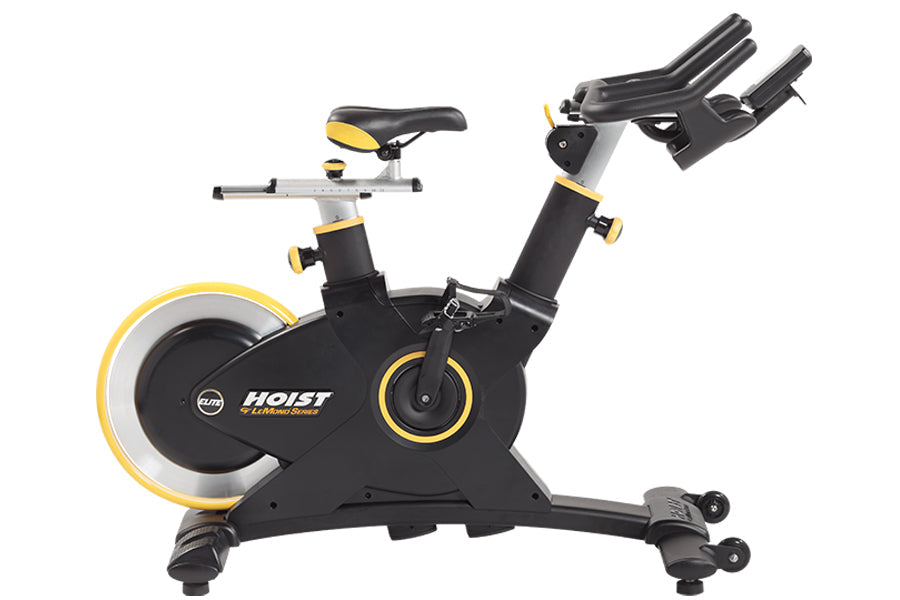 Black and yellow stationary exercise bike with adjustable handlebars, padded seat, and large weighted flywheel on white backg
