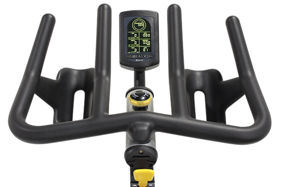 Black stationary exercise bike with dual handles, digital console displaying metrics, and yellow accent details on white back