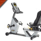 Hoist Lemond RT recumbent exercise bike with white frame, gray seat, digital display console, and black foot pedals on white 