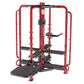 Red metal leg press and chest fly machine with black seat and footplate, on white background