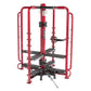 Red and black multi-station gym equipment with rounded frame, black foot platforms, and leg press attachment on white backgro