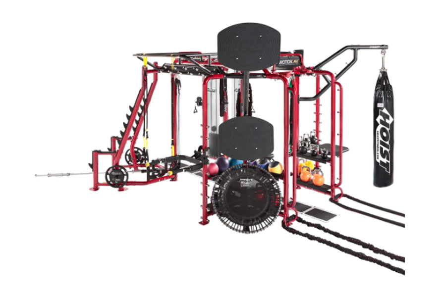 Hoist MC-7000 Series red multi-station gym cage system with black padded seats, hanging heavy bag, and cable attachments on w