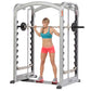 Woman wearing teal sports bra and pink shorts using silver and black Smith machine with barbell for strength training