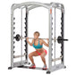 Woman in teal sports bra and red shorts performing squat on silver and black Hoist Smith Machine with barbell loaded with wei