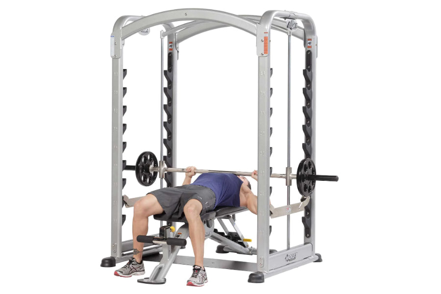 Man using silver and black dual action Smith machine with adjustable barbell on white background