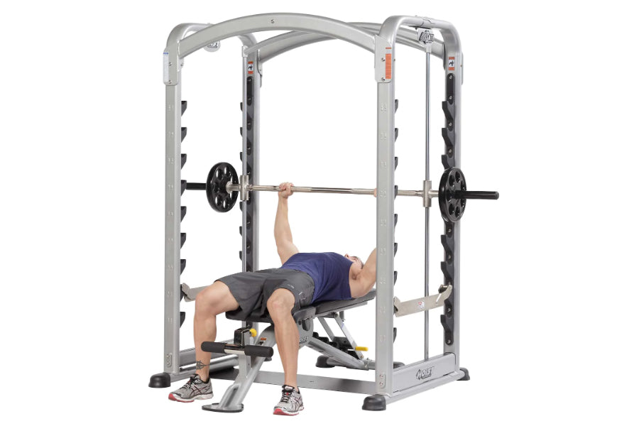 Man using silver and black Hoist Smith Machine with barbell for bench press exercise on white background