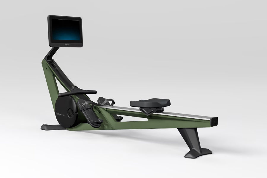 Hydrow Wave rowing machine with sage green frame, black details, digital display monitor, and black seat on white background
