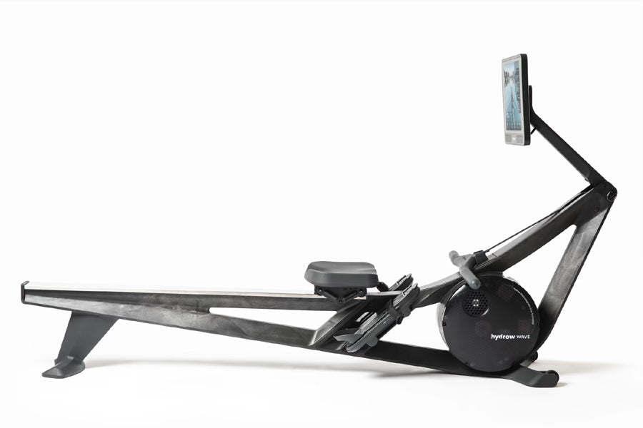 Black Hydrow Wave rowing machine with digital display arm, seat, footrest, and resistance wheel on white background