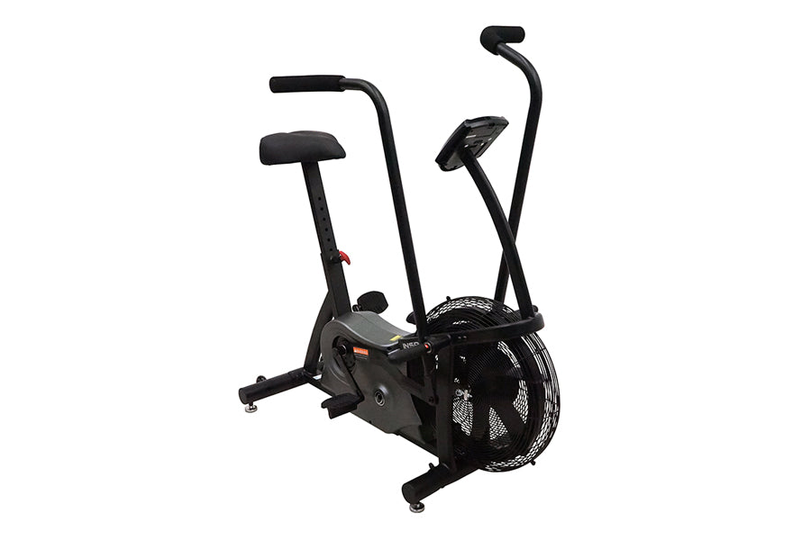 Black upright stationary air bike with dual handles, padded seat, and large fan wheel on white background